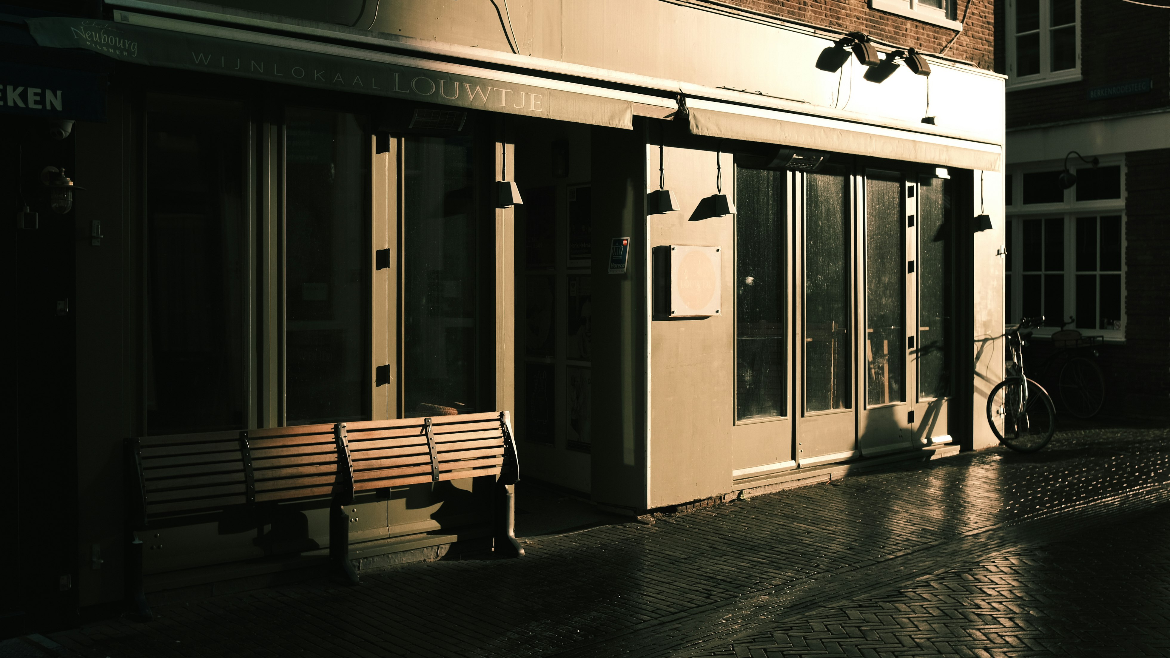 brown wooden bench beside glass window